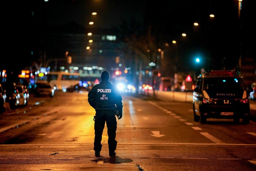 Ein einzelner Polizist steht auf einer nächtlichen Straße