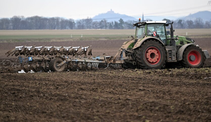 Ein Traktor zieht einen Pflug über ein Feld nahe Gotha.