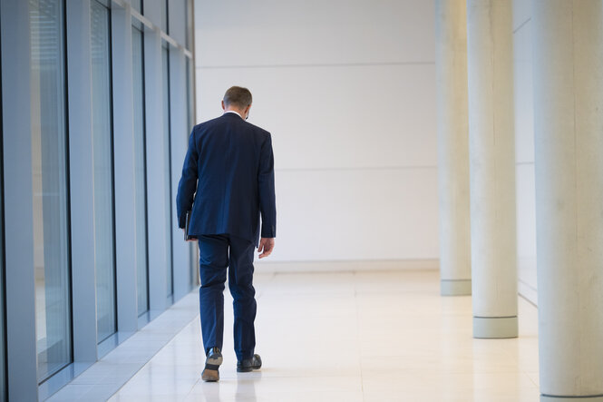 Friedrich Merz, Rückenansicht, geht durch einen Flur im bundestag