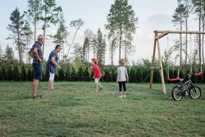 Großeltern und Enkel spielen auf einer grünen Wiese