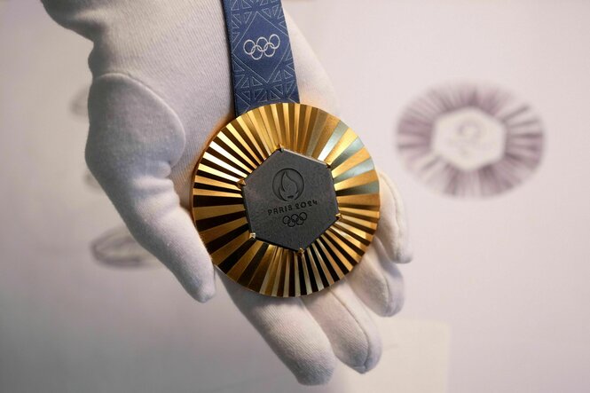 Goldmedaille auf einer Hand im weißen Handschuh präsentiert