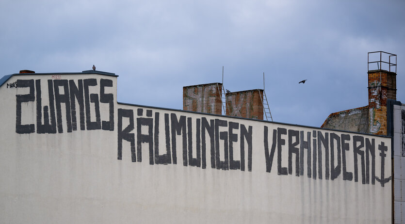 "Zwangsräumungen verhindern"-Schriftzug auf einer Häuserwand