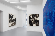 Ausstellungsansicht aus der Galerie kajetan. In der Rechten Bildhälfte ragt ein blaues Ölgemälde von Nicole Heinzel ins Bild. An den hinteren Wänden sind zwei weitere abstrakte Ölgemalde in Grau- und Beigetönen zu sehen.