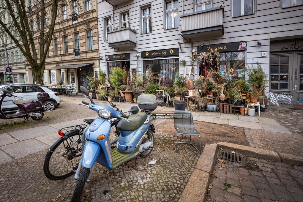 Ein blaues Mofa ist auf einer Straße im prenzlauer Berg geparkt