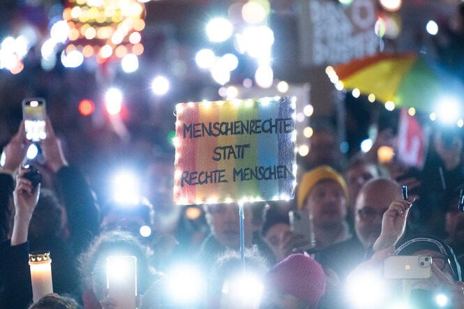 Teilnehmer halten bei der Kundgebung «Lichtermeer für den Schutz unserer Demokratie» vor dem Brandenburger Tor Lichter, Transparente und Plakate.