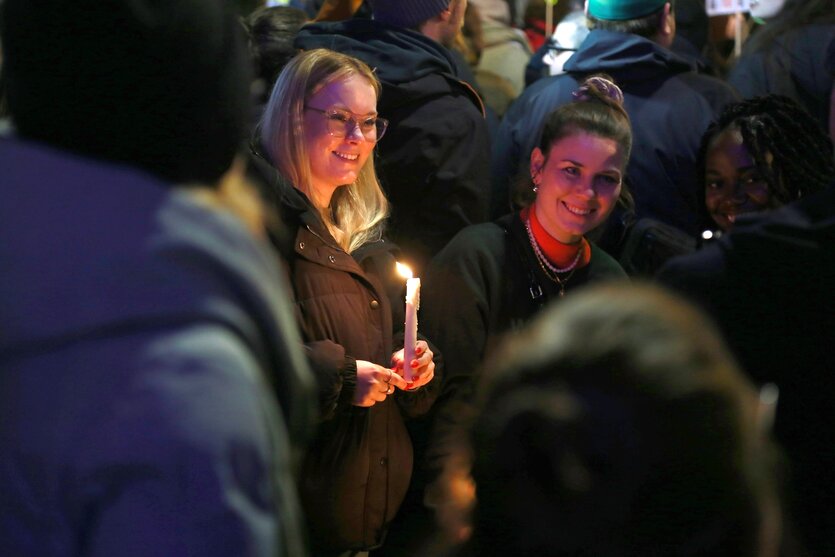 Eine Frau hält eine brennende Kerze in den Händen