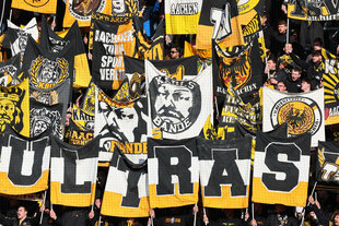 Ultras von Alemannia Aachen die Embleme der Fangruppierung Karlsbande hochhalten