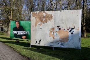 Zwei Plakatwände, auf einer sind nur noch Plakatreste, auf der anderen ein Wahlplakat der Grünen mit dem Konterfei von Robert Habeck