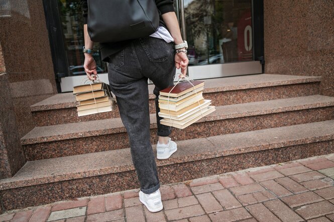 Ein Mensch trägt Bücher