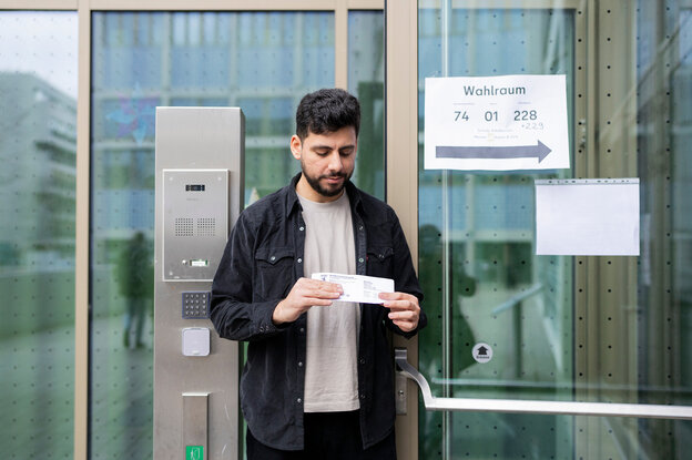 Erstwähler Nafee Kurdi steht mit seiner Wahlbenachrichtigung vor seinem Wahllokal