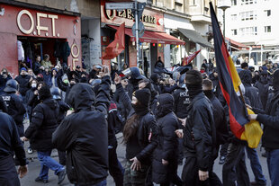 Viele Menschen bei einer Demo, alle sind schwarz gekleidet: Rechtsextremisten treffen auf linke Gegendemonstranten