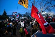 Teilnehmer einer Demonstration gegen die AfD stehen vor der Bundesgeschäftsstelle der AfD, in der der Wahlabend der Partei gefeiert wird.Sie schwenken Fahnen und Plakate mit Parolen gegen die AFD