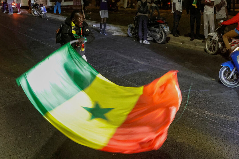 Ein Mann schwingt die Flagge des Senegal