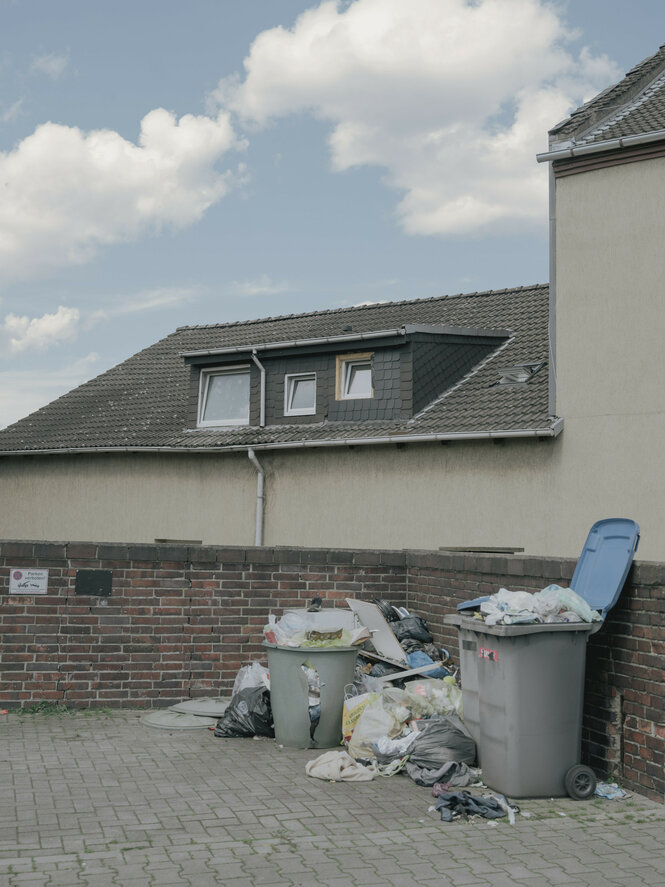 Müll in einem Hof vor einem Wohnhaus