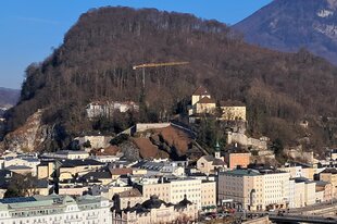 Ein gelber Kran steht auf dem Salzburger Kapuzinerberg