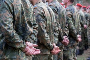 Bundeswehrsoldaten haben ihre Hände hinter den Rücken verschränkt