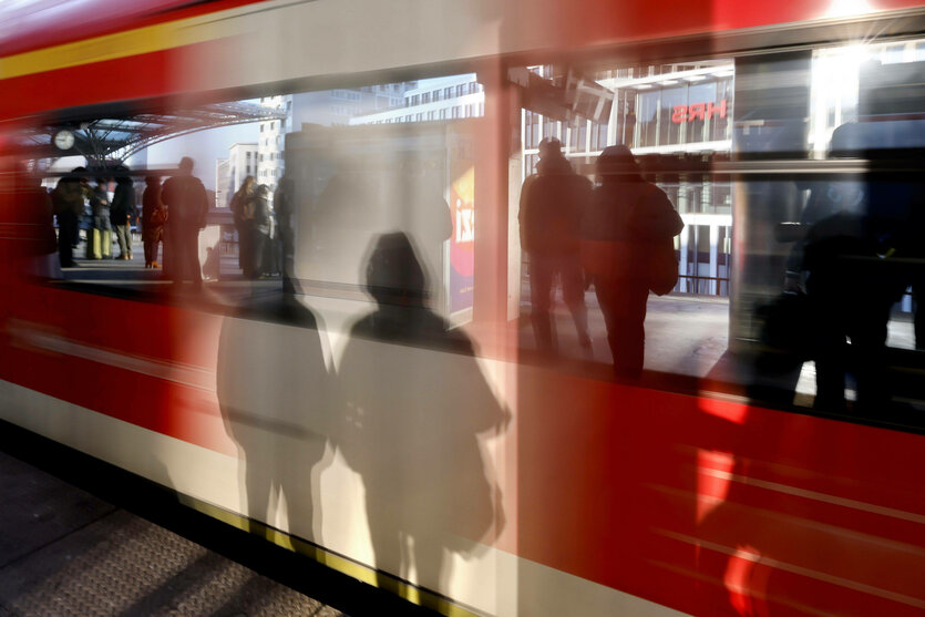 Eine S-Bahn fährt im Kölner Hauptbahnhof ein. Passanten spiegeln sich in den Fenstern