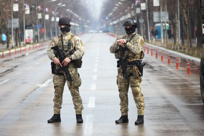 Zwei schwerbewaffnete Soldaten stehen auf einer abgeriegelten Straße in Banja Luka