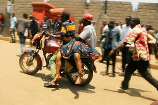 Ein Opfer des Bombenanschlags wird mit dem Motorrad transportiert, das Bild ist durch die Bewegung unscharf.