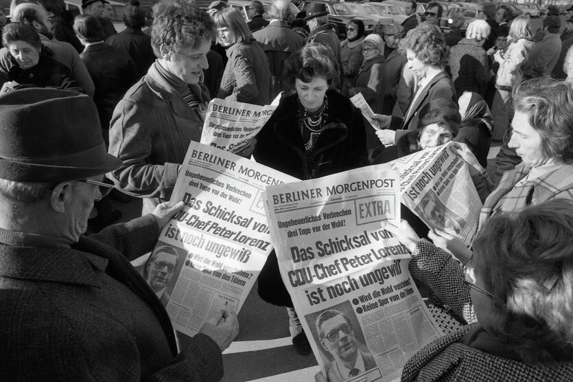 Westberliner lesen Sonderausgaben der Berliner Morgenpost zur Entführung von Peter Lorenz.