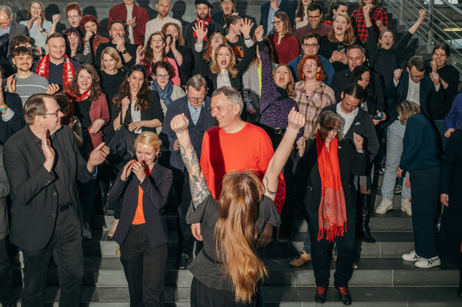 Eine Menschengruppe formiert sich für ein Gruppenbild