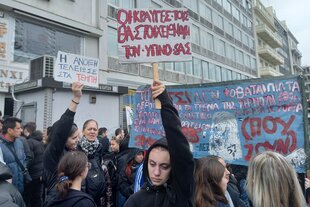 Eine junge Demonstrantin hält bei einem Massenprotest in Athen ein Schild mit der Aufschrift hoch: "Ihre Schreie werden euren Schlaf begleiten"