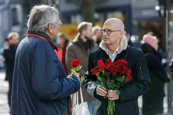 Hamburgs Erster Bürgermeister uns SPD-Spitzenkandidat Peter Tschentscher verteilt ian einem Wahlkampfstand Rosen