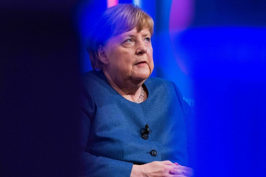 Ex-Bundeskanzlerin Angela Merkel mit blauer Jacke schaut ernst