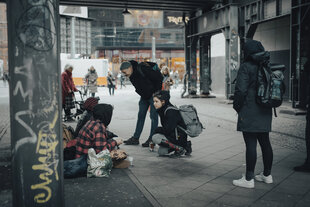 Sozialarbeiter betreuen einen obdachlosen Menschen unter einer Brücke beim Alexanderplatz