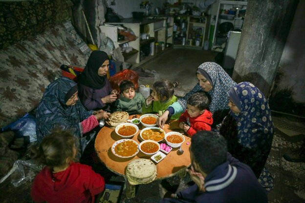 Eine Familie sitzt um einen Tisch mit Essen