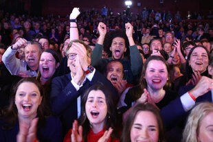 Jubelnde Personen auf einer Wahlparty.