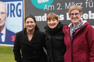 Heike Sudmann, Heidi Reichinnek und Cansu Özdemir vor einem Wahlplakat.