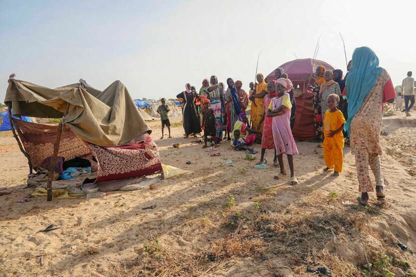 Afrikanische Menschen vor provisorischen Zelten