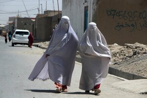 Zwei Frauen, die Burkas tragen, gehen eine Straße entlang