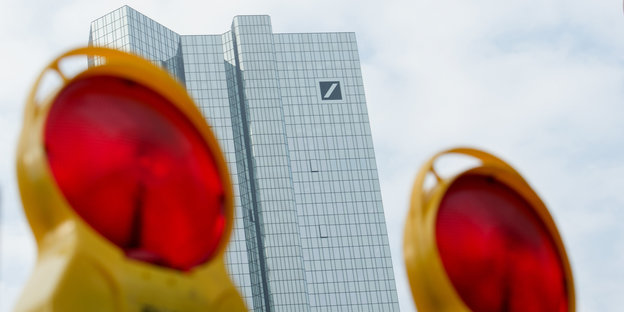 Zwei rote Baulichter stehen vor dem Deutsche Bank Gebäude