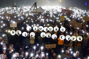 Demonstrant:innen halten beschriftete Luftballons in die Luft. Auf ihnen steht: 