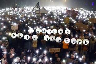 Demonstrant:innen halten beschriftete Luftballons in die Luft. Auf ihnen steht: "Hamburg hält dagegen".