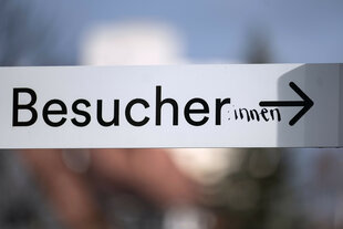 Das Wort "Besucher" ist auf einem Schild in der Innenstadt mit dem Zusatz ":innen" versehen.