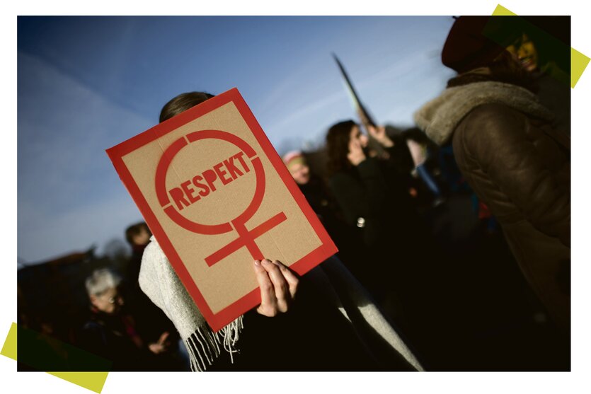 Eine Frau demonstriert mit einem Plakat auf dem das Frauenzeichen zu sehn und das Wort "Respekt" zu elsen ist