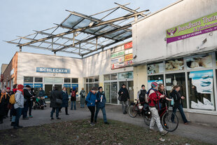 Menschen vor einem leerstehenden Shopping-Center in Hellersdorf