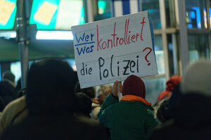 Demonstranten halten ein Schild hoch: 