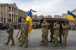 Ukrainische Soldaten tragen einen Sarg