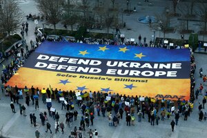 Menschen mit eine blau-gelben Fahne auf der DDefend Ukraine Defend Europe