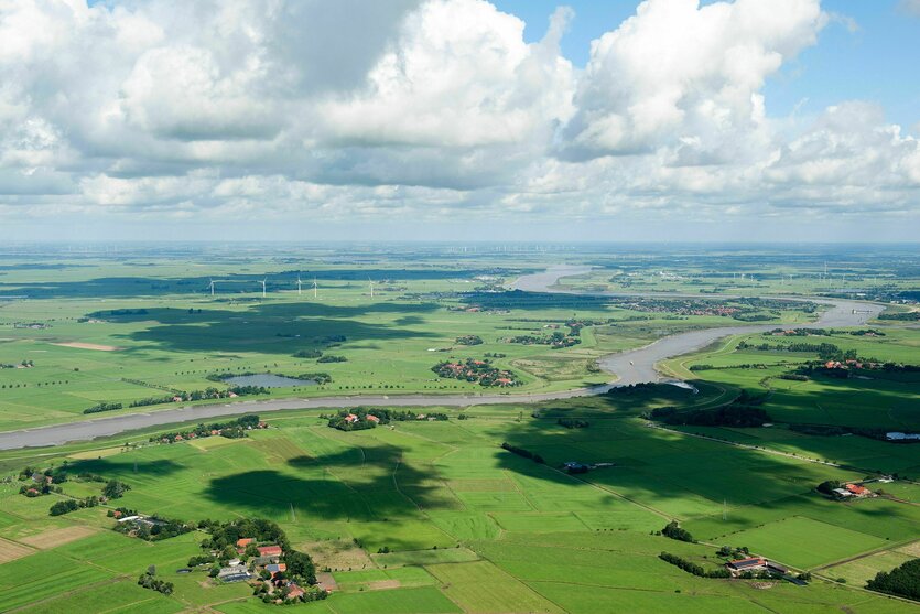 Luftaufnahme: ein Fluss schlägelt sich durch eine grüne Landschaft