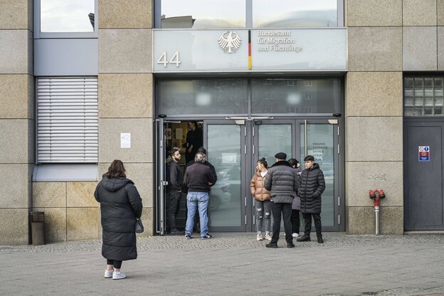 Menschen warten vor einer Behörde