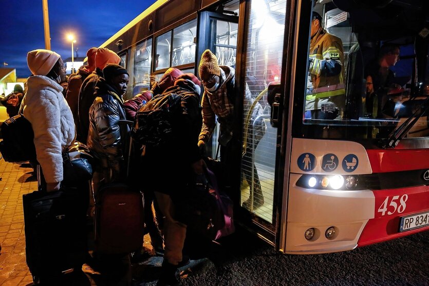 Menschen steigen in einen Bus, nächtliche Szene