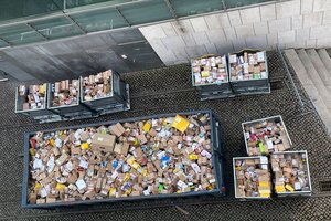 Randvolle Container mit Paketen in einem Hof