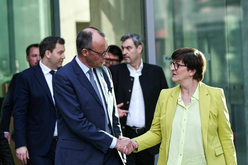 Friedrich Merz gibt Saskia Esken die Hand. Im Hintergrund sind Lars Klingbeil, SPD-Fraktions- und Bundesvorsitzender, und Markus Söder (CSU), Ministerpräsident von Bayern.