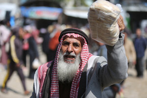 ein palästinensischer Mann in Gaza mit Brot in der Hand