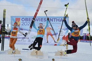 Drei Skispringerinnen springen auf dem Spiegerpodest in die Luft